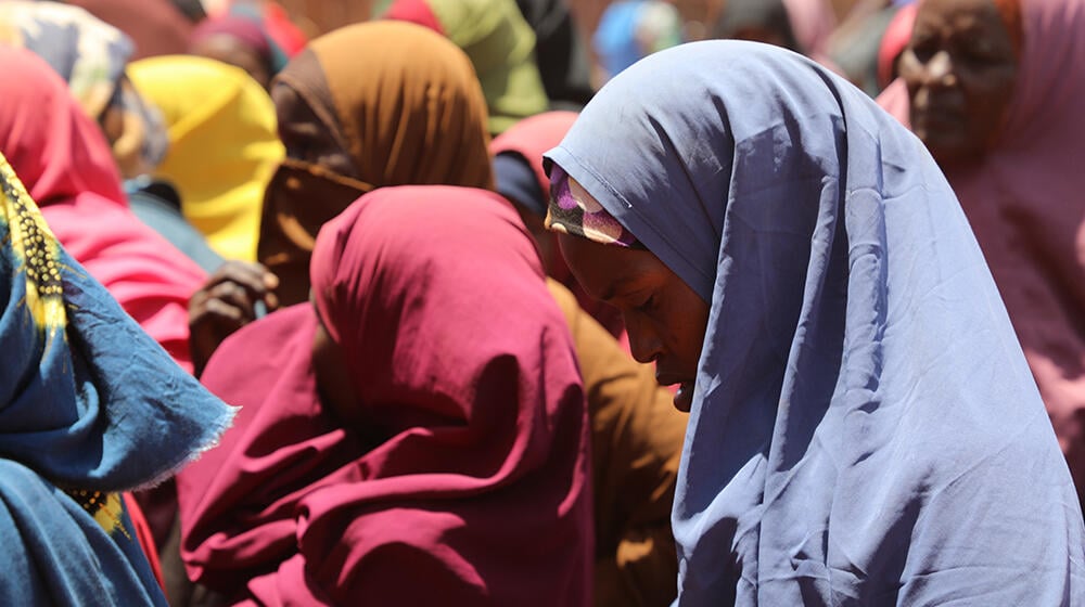 Women wait outside a One Stop Centre for a chance to be registered